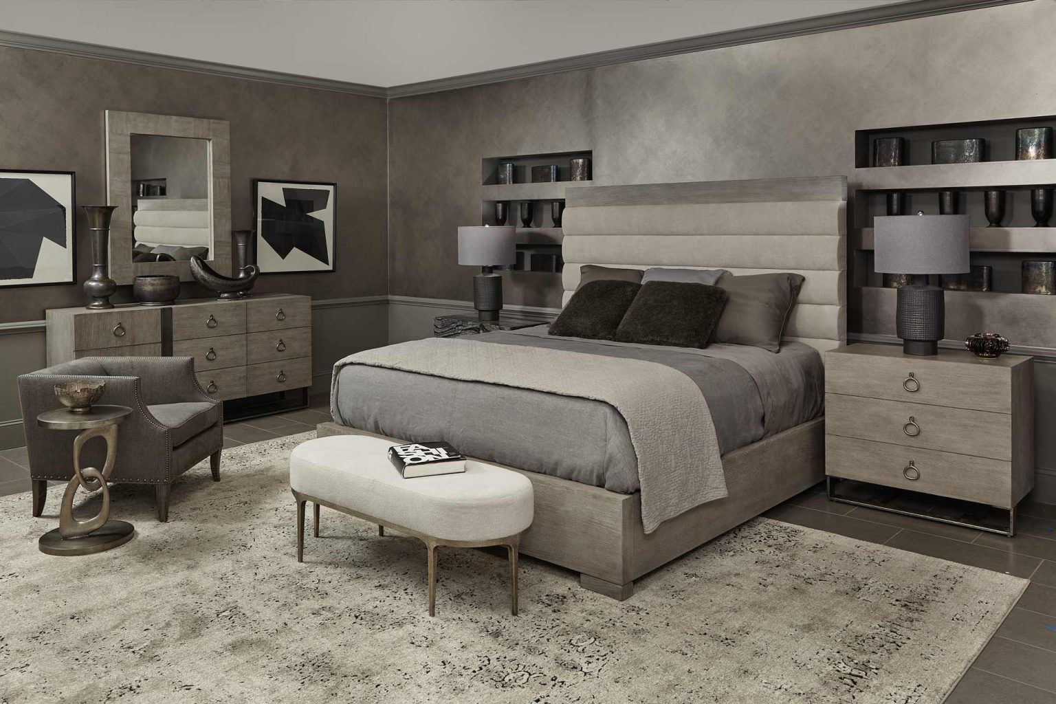 Muted gray bedroom with bed, nightstands, dresser, and bench.